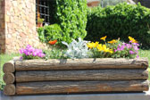 Jardinera rectangular rústica de troncos con pela