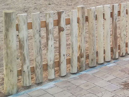 Valla rústica con troncos de madera de acacia